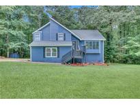 Charming two-story home with blue siding, landscaped front yard, and inviting front porch at 3706 Londonderry Ct, Lithonia, GA 30038