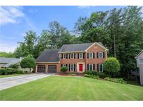 Charming two-story brick home featuring an attached two-car garage and a well-manicured lawn at 2214 Trilleck Nw Dr, Kennesaw, GA 30152