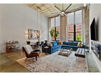 Bright, open living room with high ceilings, exposed brick, large windows, and stylish modern decor at 170 Boulevard Se # E120, Atlanta, GA 30312