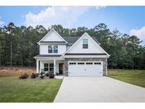 Charming two-story home featuring a well-manicured lawn, inviting front porch, and a two-car garage at 93 Oakdale Way, Temple, GA 30179