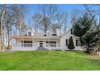 Charming white two-story home featuring a welcoming front porch and well-manicured lawn at 4100 Summer Wood Dr, Snellville, GA 30039