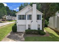 Charming two-story home featuring a cozy front porch, attached garage, and well-maintained landscaping at 800 Tradd Ct, Stone Mountain, GA 30087