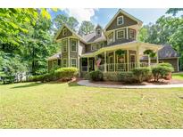 Charming two-story home with lush lawn and inviting wraparound porch, perfect for enjoying peaceful outdoor living at 220 Mars Hill Rd, Powder Springs, GA 30127