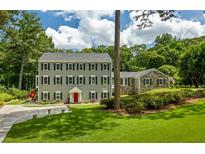 Charming traditional home with a symmetrical facade, lush lawn, and a welcoming red front door at 555 Valley Hall Dr, Atlanta, GA 30350