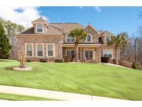 Stunning two-story brick home with a well-manicured lawn and mature palm trees at 1227 Castle Point Sw Ct, Conyers, GA 30094