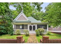Charming home featuring a picturesque front porch and lush landscaping at 240 Melrose Ave, Decatur, GA 30030