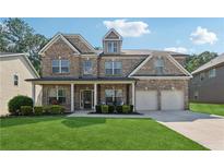 Charming two-story brick home with a well-manicured lawn and inviting front porch at 2629 Muskeg Sw Ct, Atlanta, GA 30331