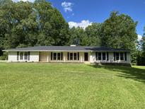 Charming single-story home with a well-manicured lawn and mature trees providing a peaceful and inviting setting at 3975 N Sharon Church N Rd, Loganville, GA 30052