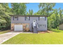 Charming two-story home with stone accents, landscaped front yard, and gray siding at 6906 Shangrila Way, Riverdale, GA 30296
