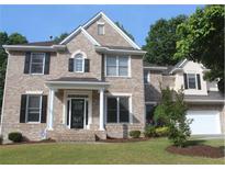 Charming two-story brick home with a well-manicured lawn, black shutters, and a bright, two-car garage at 733 Miller Run Run, Atlanta, GA 30349