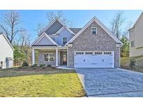 Charming two-story home with a brick facade, complemented by a well-manicured lawn and a two-car garage at 1436 Weeping Tree Dr, Auburn, GA 30011