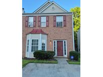 Charming two-story brick home with bay window, red shutters and a well maintained front yard at 5570 Hampton Ct, Atlanta, GA 30349