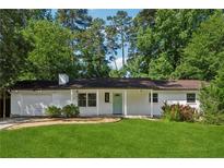 Charming one-story home with a well-manicured lawn and light blue front door at 3123 Deshong Dr, Stone Mountain, GA 30087