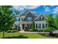 Beautiful two-story home featuring a well-manicured lawn and appealing brick and stone facade at 3755 Valleyway Rd, Cumming, GA 30040