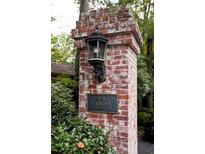 View of Emory Garden Condominiums sign with lantern on brick pillar surrounded by trees at 1131 Clairemont Ave # B, Decatur, GA 30030