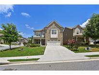 Charming two-story home with brick and siding exterior, well-manicured lawn and an attached two car garage at 2300 Ivy Birch Ln, Buford, GA 30519