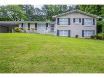 Charming two-story brick home with a well-maintained lawn and covered parking at 3030 Golden Dr, Atlanta, GA 30344