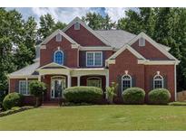 Charming two-story red brick home featuring a well-manicured lawn and attractive landscaping at 2625 Morningside Nw Trl, Kennesaw, GA 30144