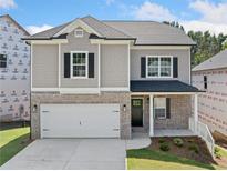 Charming two-story home featuring brick and siding, a two-car garage, and a well-manicured front yard at 419 Crestmont Ln, Canton, GA 30114