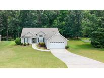 Charming single-story home featuring a well-manicured lawn and inviting curb appeal at 555 Flintlock Dr, Dacula, GA 30019