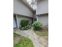 Modest home exterior featuring light siding and a small garden at 8562 Creekwood Way, Jonesboro, GA 30238