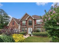Charming two-story brick home featuring manicured landscaping and a welcoming front entrance at 11961 Markham Way, Hampton, GA 30228