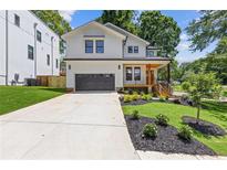 Charming two-story home featuring a modern farmhouse design, landscaped yard and a wide driveway at 3155 Zion St, Scottdale, GA 30079