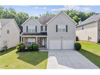 Charming two-story home with stone accents, well-maintained lawn, and a two-car garage at 4420 Ambassador Way, Cumming, GA 30040