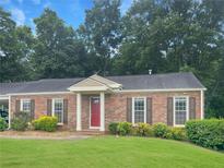 Charming brick home featuring a well-manicured lawn and a welcoming red front door at 365 Norcross St, Roswell, GA 30075