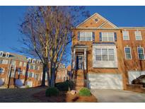 Charming brick townhome featuring a manicured lawn, attached garage, and classic architectural details at 401 Iona Abbey Ct # 6, Smyrna, GA 30082