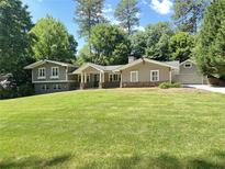 Charming home featuring a lush green lawn, well manicured landscaping and a welcoming front porch at 2062 Valiant Ne Dr, Atlanta, GA 30345