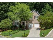 Charming brick home with a two-car garage, lush landscaping, and a welcoming driveway at 3788 Westwick Nw Ct, Kennesaw, GA 30152