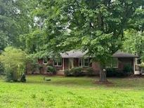 Traditional brick home with a mature tree in the front yard providing shade and curb appeal at 4485 Canary Ct, Lithia Springs, GA 30122