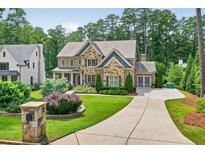 Beautiful stone and brick home with lush landscaping and a curved driveway at 6470 Long Island Nw Dr, Atlanta, GA 30328