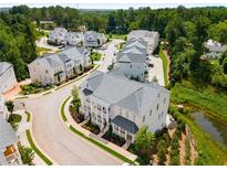 Community aerial view showcases craftsman townhomes, landscaped yards, and a tranquil water feature at 2125 Parkside Ln, Roswell, GA 30076