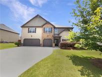 Charming two-story home featuring a two-car garage, neutral siding, and stone accents at 622 Madison Park Dr, Grayson, GA 30017