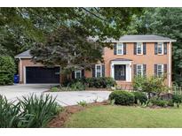 Charming two-story brick home with a well-manicured lawn and mature landscaping at 1379 Cambridge Ne Ct, Brookhaven, GA 30319