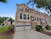 Charming brick townhouse with a two-car garage and well-maintained landscaping at 2231 Mill Garden Pl, Buford, GA 30519