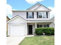 Charming two-story home with a well-manicured lawn, an attached garage, and inviting front entrance at 515 Brady Dr, Villa Rica, GA 30180