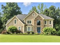 Stunning two-story home featuring stone accents, a manicured lawn, and lush landscaping at 5807 Brookstone Nw Walk, Acworth, GA 30101