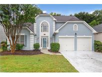 Charming light blue two-story home featuring a two-car garage and manicured landscaping at 845 Melbourne Trl, Alpharetta, GA 30009