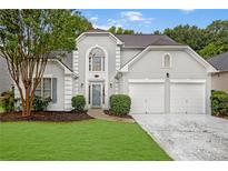 Charming two-story home featuring well-manicured lawn, mature trees, and an attached two-car garage at 845 Melbourne Trl, Alpharetta, GA 30009