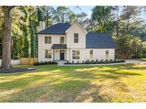 Beautifully renovated two-story home with a lush lawn and modern farmhouse design at 2135 Huntington Dr, Loganville, GA 30052