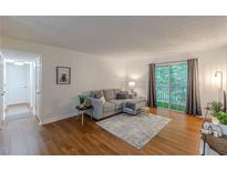 Bright living room with hardwood floors, neutral colors, and a sliding glass door to the outside at 3135 Seven Pines Ct # 8, Atlanta, GA 30339