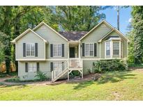 Charming split-level home with green siding, black shutters, and a inviting front entrance with a stairway at 94 Park W Ave, Dallas, GA 30157