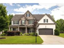 Charming two-story home featuring a stone and brick facade, well-manicured lawn, and an attached two-car garage at 374 Heritage, Woodstock, GA 30188
