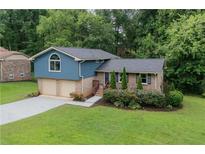 Charming home featuring a manicured lawn, a brick facade, and a two-car garage at 4345 Tucker North Dr, Tucker, GA 30084