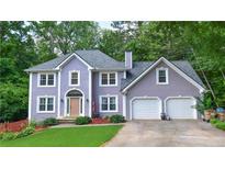 Charming two-story home boasts a well-manicured lawn, inviting entrance, and a convenient two-car garage at 5028 Jamie Ne Ct, Woodstock, GA 30188