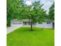 Charming single-story home featuring a lush green lawn and a welcoming front yard at 120 Lakeside Dr, Ellenwood, GA 30294