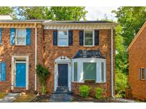 Charming brick townhome featuring classic architectural details and a beautifully landscaped front yard at 4417 Village Square Ln, Stone Mountain, GA 30083